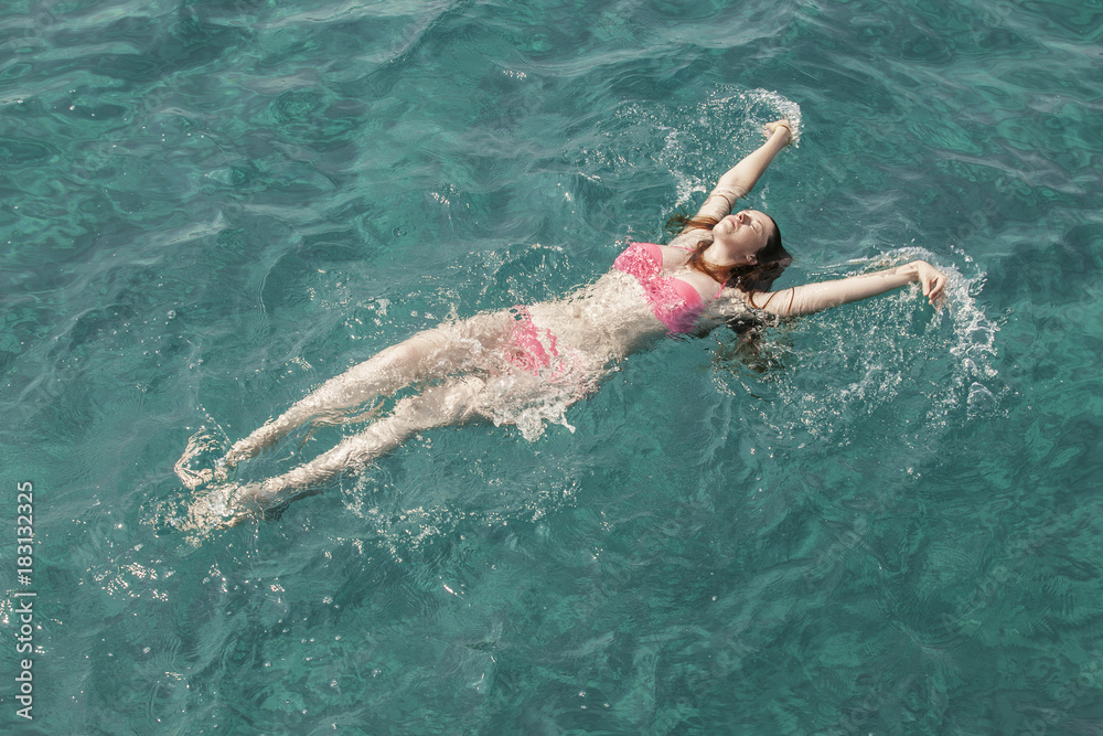 beautiful girl swims in the sea