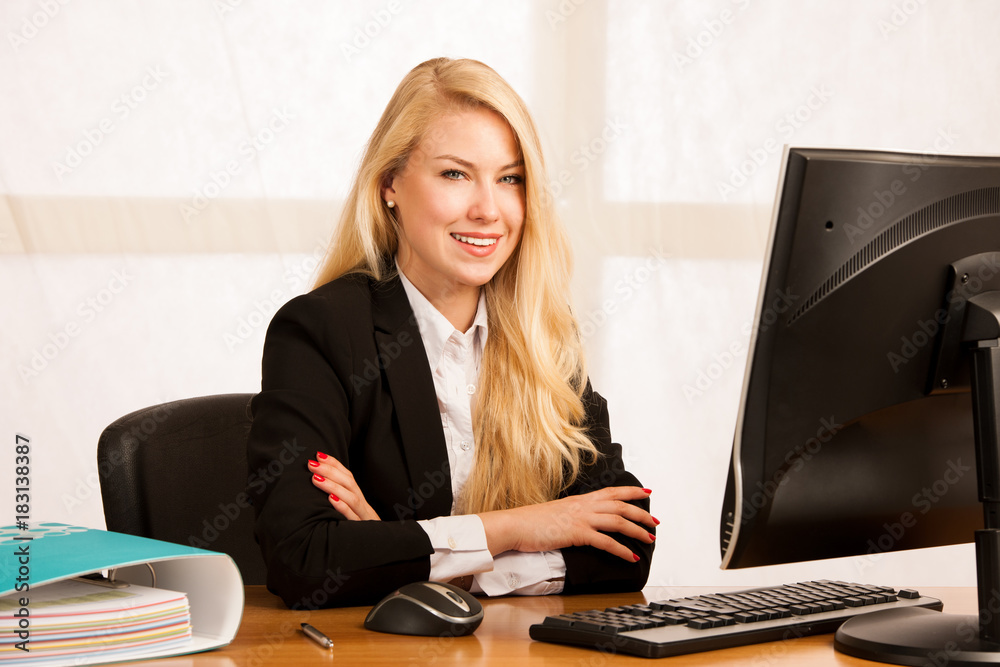 Beautiful young blonde woman working on computer in her office Beautiful young blonde woman working on computer in her office