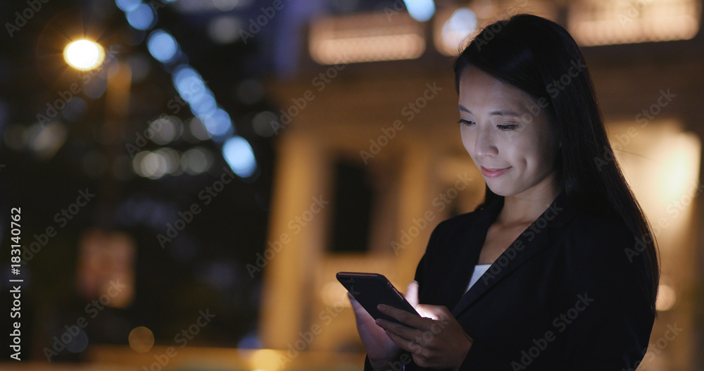 Businesswoman use of smart phone in city at night
