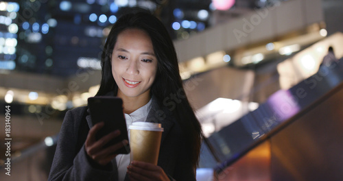 Businesswoman use of mobile phone with coffee cup