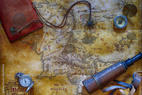 Ancient map (possibly pirate or treasure or middle-earth) with adventure attributes stuff (compass, notepad, telescope and pocket watch) around the perimeter