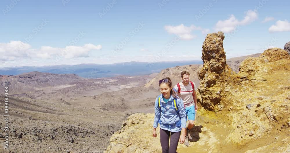 New Zealand Hiking Couple Backpackers Tramping At Tongariro National Park. Male and female hikers hiking on Tongariro Alpine Crossing . People living healthy active lifestyle outdoors SLOW MOTION. New Zealand Hiking Couple Backpackers Tramping At Tongariro National Park. Male and female hikers hiking on Tongariro Alpine Crossing . People living healthy active lifestyle outdoors SLOW MOTION.