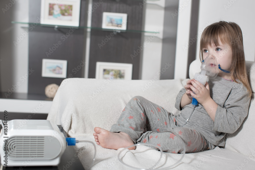 Little girl making inhalation with nebulizer at home. child asthma inhaler inhalation nebulizer steam sick cough concept Little girl making inhalation with nebulizer at home. child asthma inhaler inhalation nebulizer steam sick cough concept
