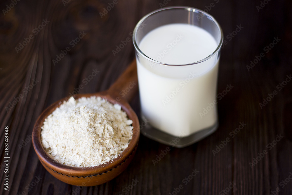 porridge in a clay pot and a glass of milk on a wooden table porridge in a clay pot and a glass of milk on a wooden table