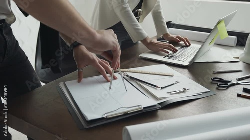Close-up.Two architects working with a laptop, compasses and drawings for an architectural plan photo