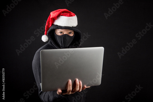 mysterious male santa hacker holding laptop computer photo