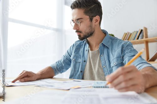 Quadro em tela Serious concentrated male worker checks and analyzes information from business r