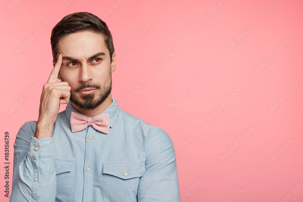 Thoughtful handsome man thinks about how make proposal to girlfriend, wears festive cloths, prepares for special occasion in his life, tries to imagine romantic supper with lover. Copy space. Thoughtful handsome man thinks about how make proposal to girlfriend, wears festive cloths, prepares for special occasion in his life, tries to imagine romantic supper with lover. Copy space.
