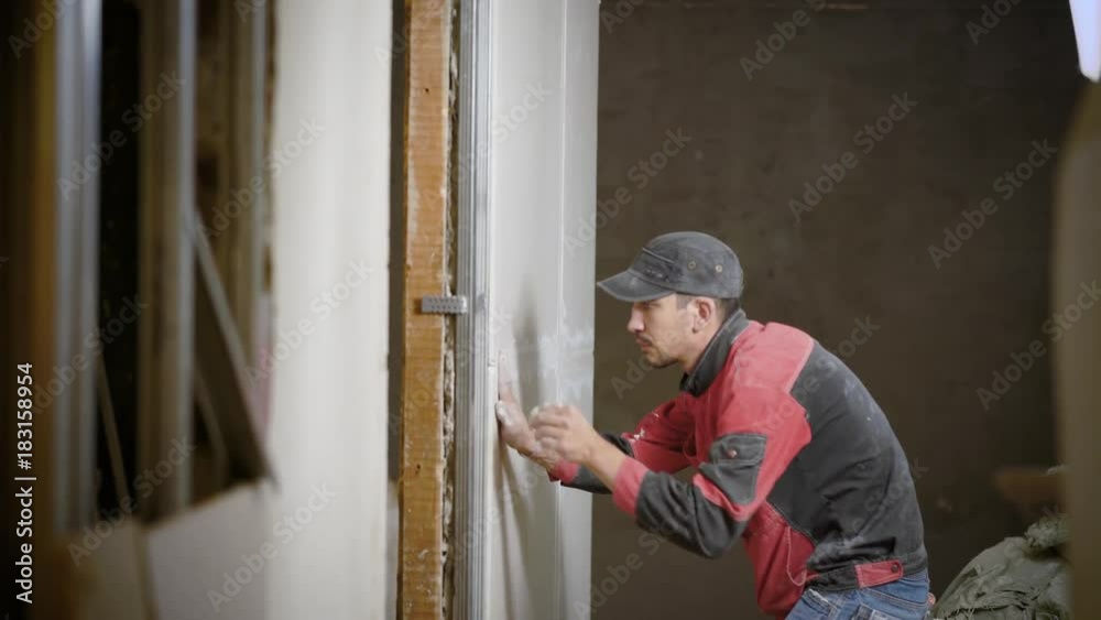 Handyman working on decorating interior wall applying stucco Handyman working on decorating interior wall applying stucco