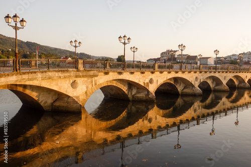 Old stone bridge on the river during sunset evening