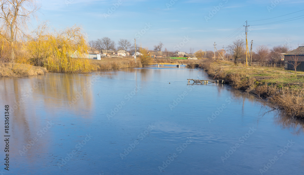 Autumnal landscape with starting to freeze Orchyk river in Karlovka town, Ukraine
