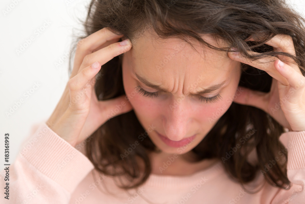 Young woman having a headache due to stress and anxiety - Burn out concept Young woman having a headache due to stress and anxiety - Burn out concept