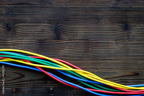 Network wires assorted colors on dark wooden background top view copyspace