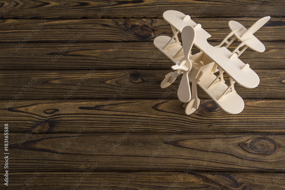 Wooden toy plane carved model on wooden old table. With a place for design Wooden toy plane carved model on wooden old table. With a place for design