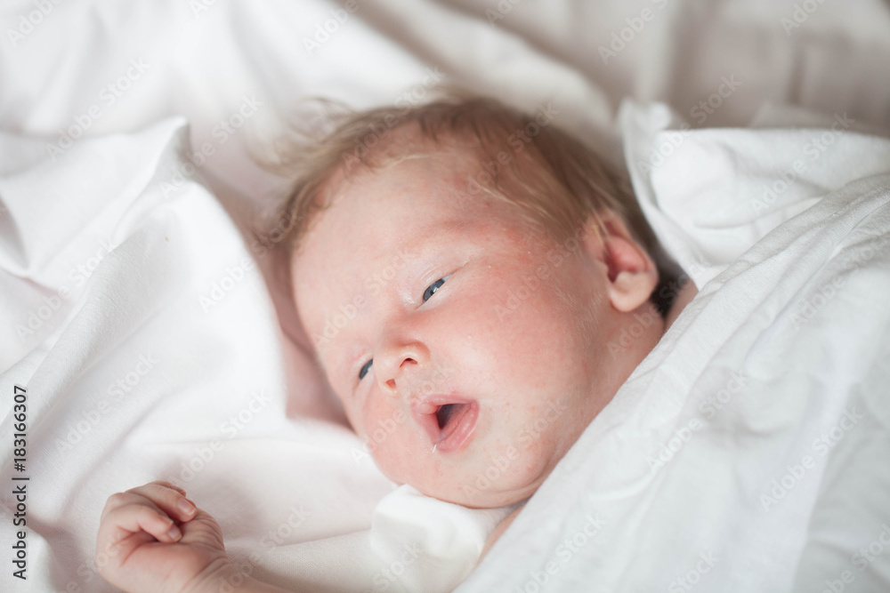 Peaceful baby lying on a bed while sleeping in a bright room Peaceful baby lying on a bed while sleeping in a bright room