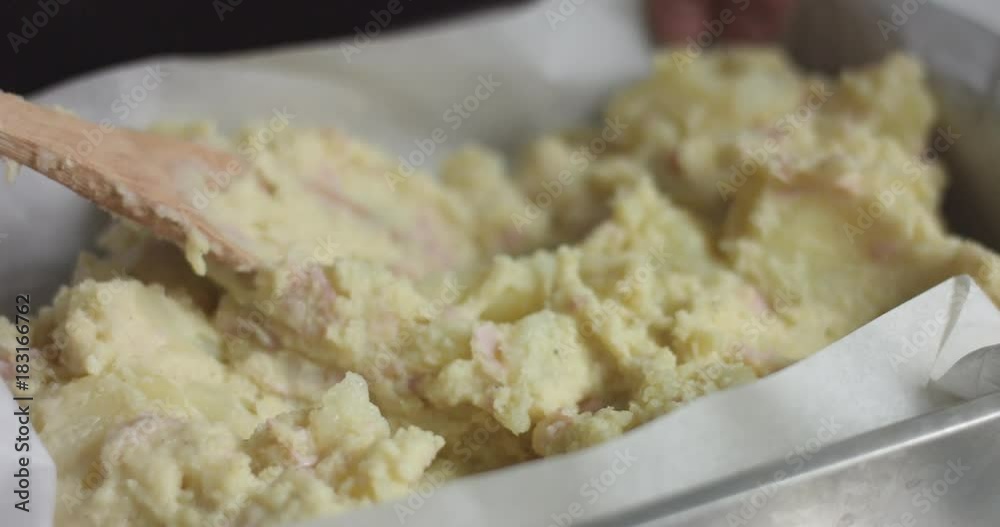 Adding ham, bechamel sauce and cheese to homemade potato casserole bread for Christmas dinner Adding ham, bechamel sauce and cheese to homemade potato casserole bread for Christmas dinner