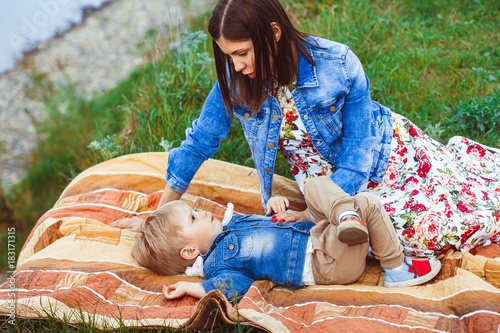 mother and son lying on the grass photo