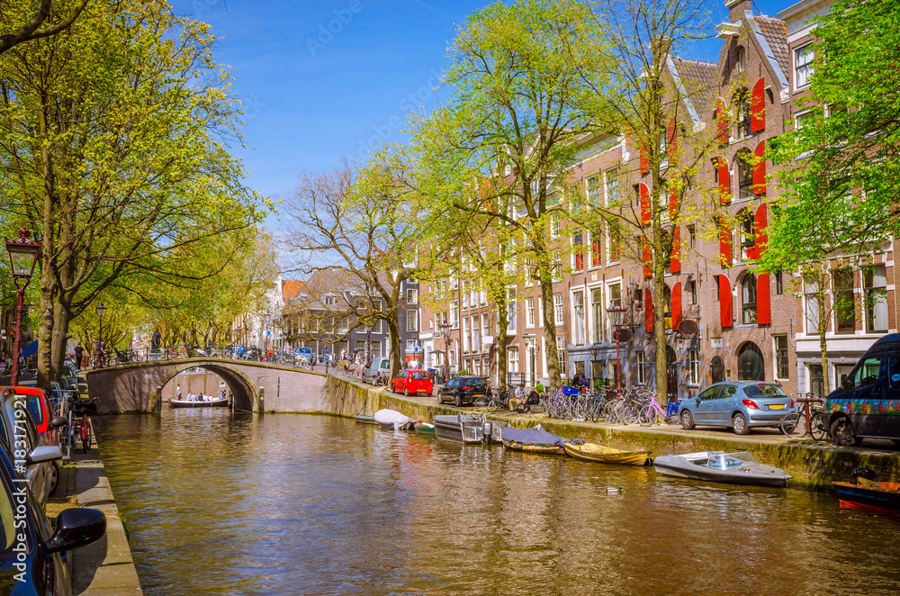 Traditional old buildings and boats in Amsterdam, Netherlands. Canals of Amsterdam.