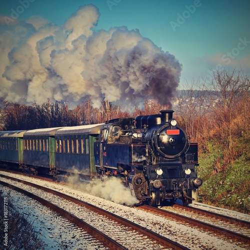 Beautiful old steam train with wagons running on rails at sunset. Excursions for children and parents on festive special days. Czech Republic Europe.