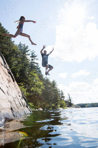 Obraz na płótnie Kids jumping into the river during a camping trip w salonie