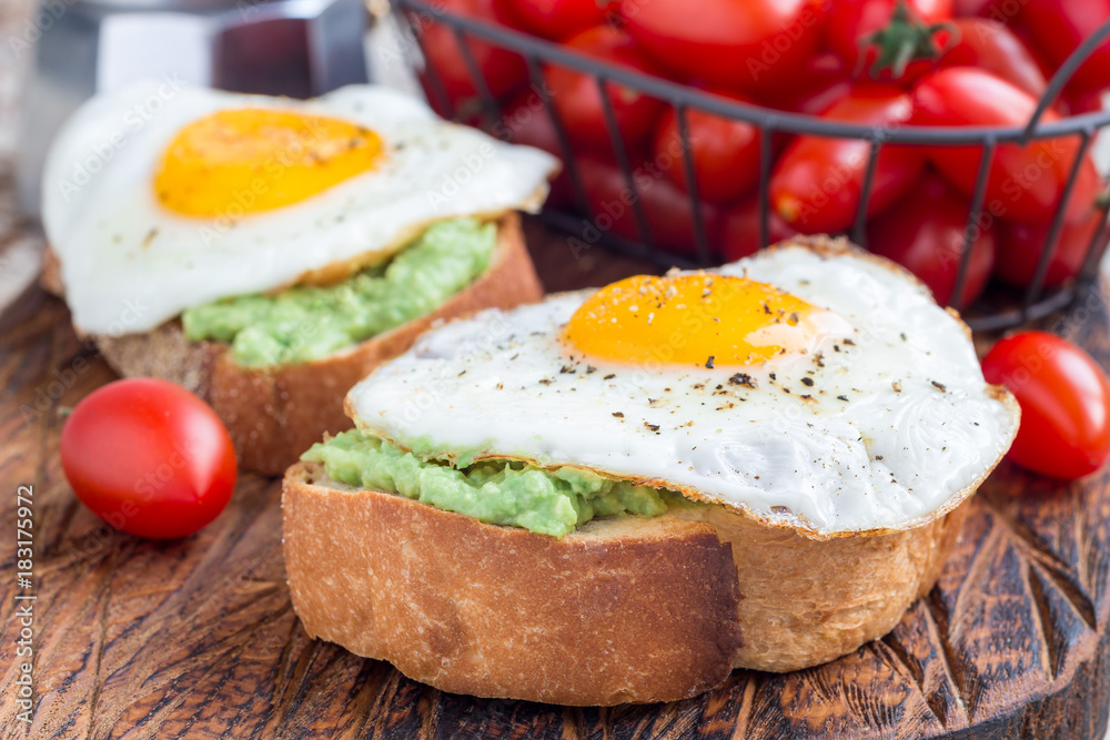 Open sandwiches with mashed avocado and fried egg, horizontal Open sandwiches with mashed avocado and fried egg, horizontal