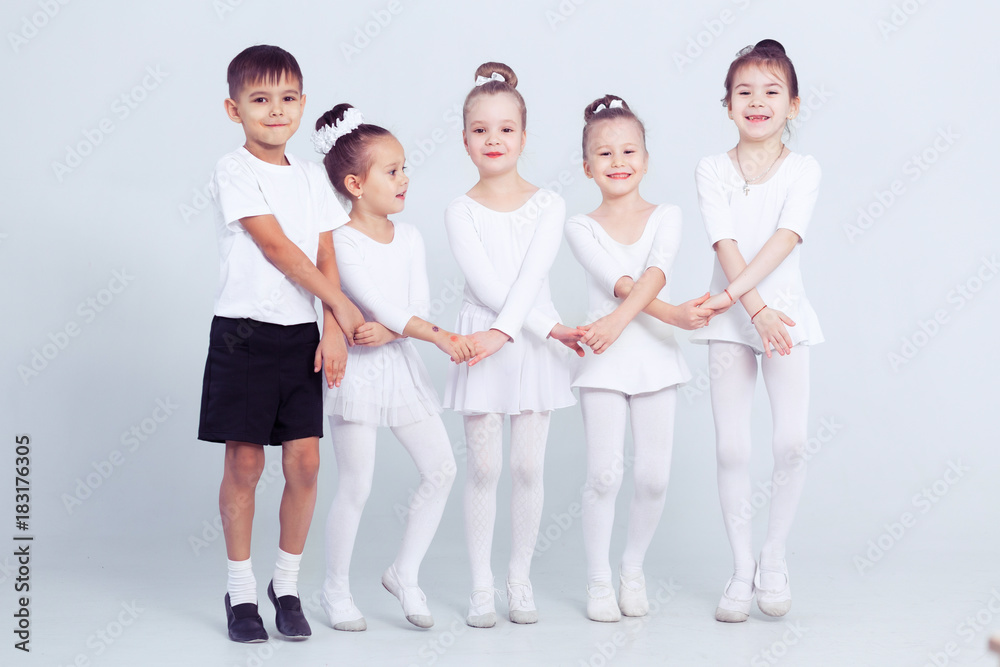Little ballerinas and kid ballerun doing exercises and sitting on floor in white ballet class. Little ballerinas and kid ballerun doing exercises and sitting on floor in white ballet class.