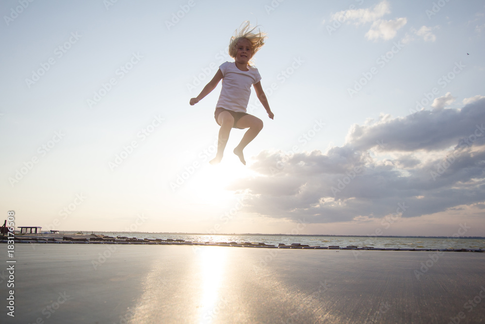 little girl jump and having good time on trampoline in summer time little girl jump and having good time on trampoline in summer time