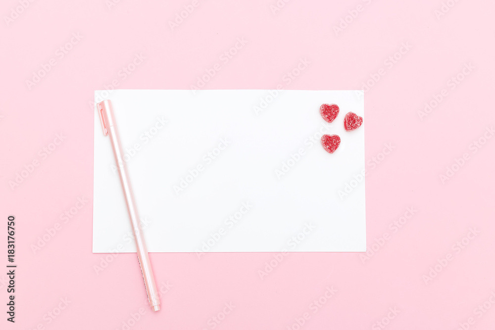 Note and pen with candies in the form of a heart. Valentine's Day
