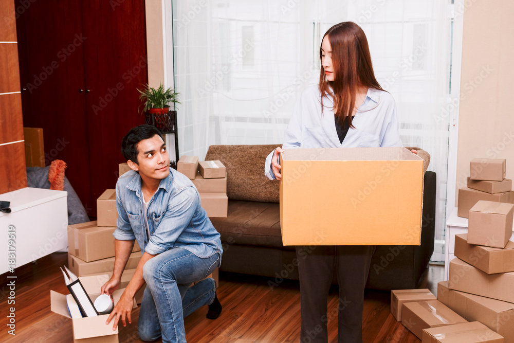 Happy couple packing boxes and moving into new home.Moving house