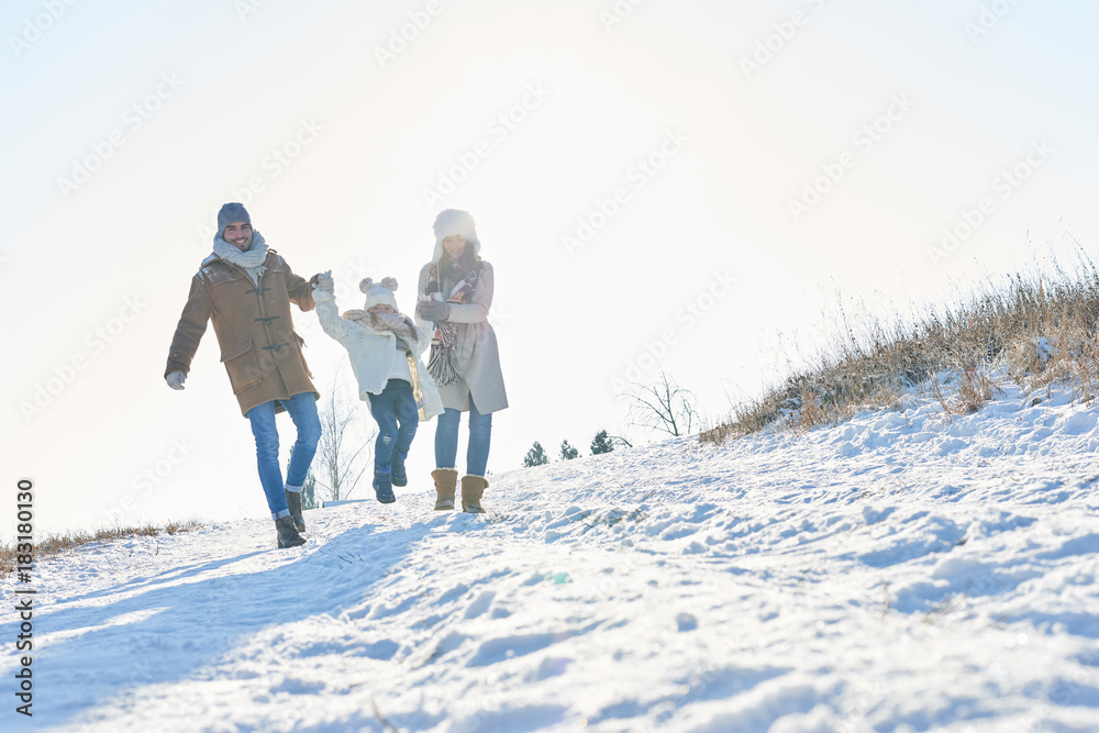 Glückliche Familie geht im Schnee spazieren
