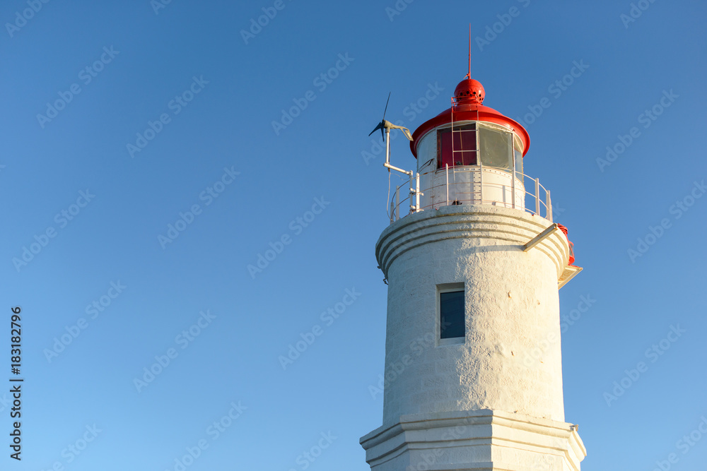 Lighthouse on the seacoast at sunset light.