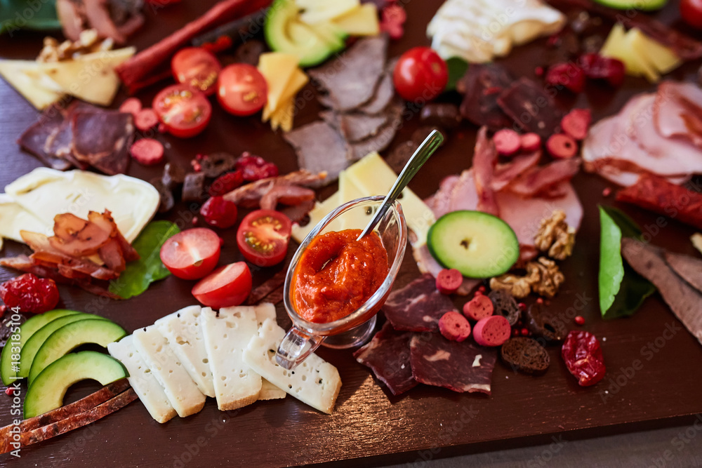 different cold appetizers cheese and meat on a wooden table