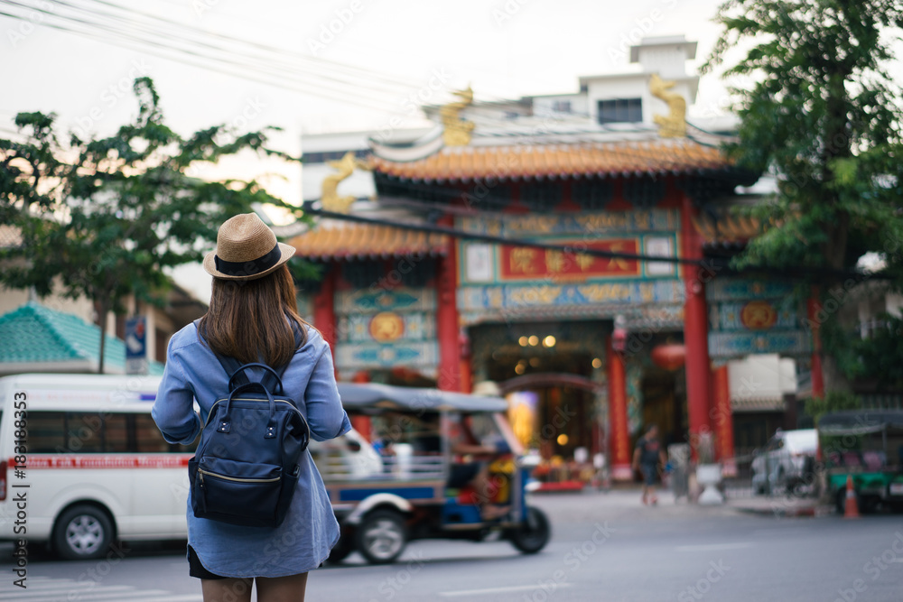 Φωτογραφία Young asian woman traveler with blue backpack and hipster hat looking view of Chinese temple with tuk tuk Thailand background at China Town Bangkok