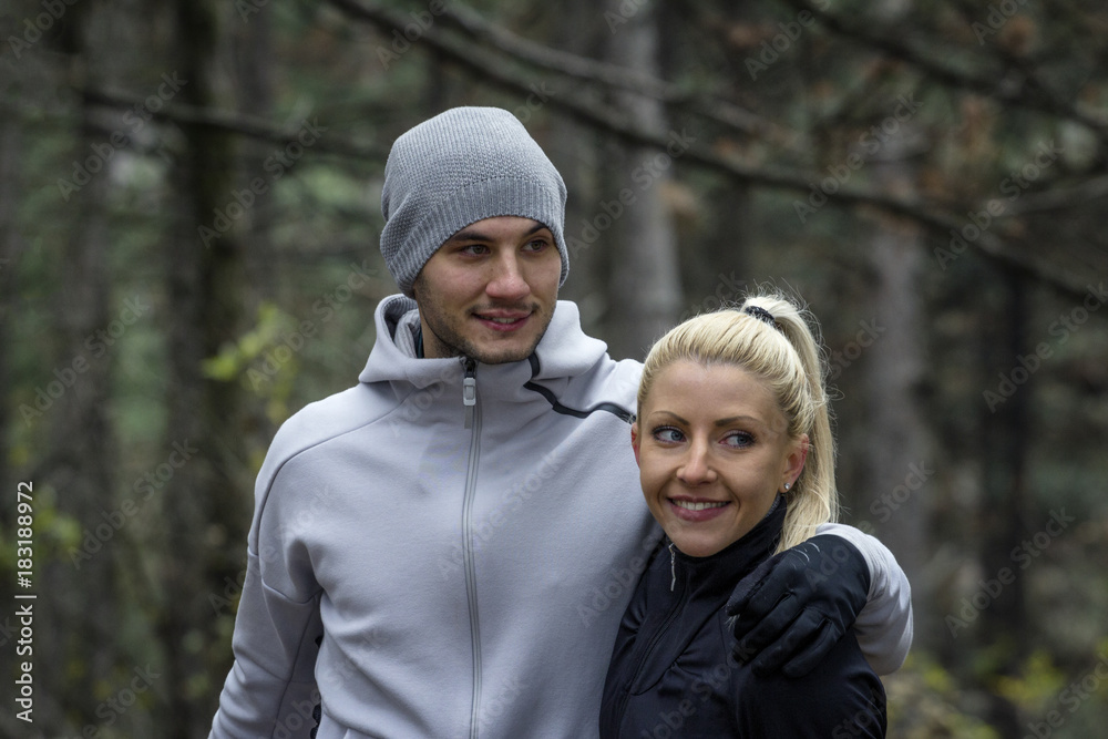 Fototapeta premium Young couple in sportwear in the middle of the forest relaxing before easy jogging in nature