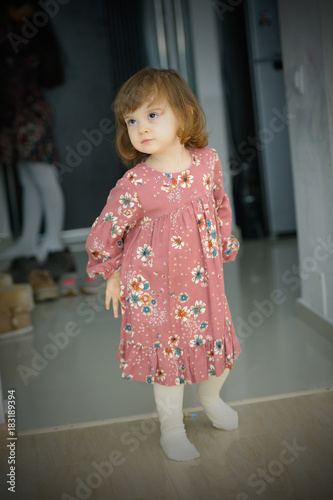 little girl with flower dress posing for the photographer