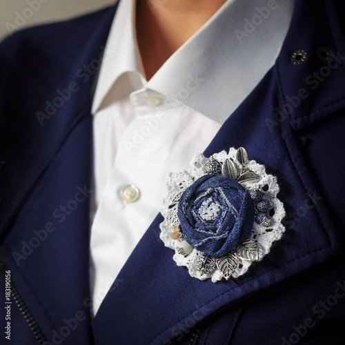 Brooch handmade in the form of a flower from denim as additional accessory of a woman business suit