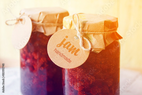 Strawberry jam. Glass jar of strawberry jam with a label. Toned photo