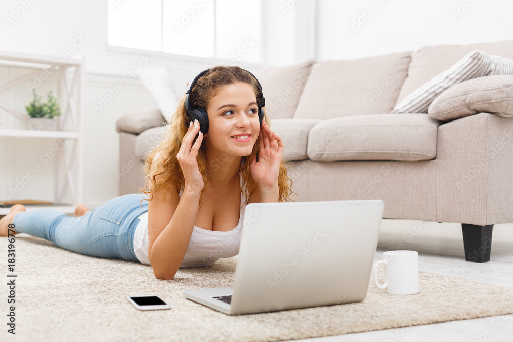 Smiling student girl using laptop on floor Smiling student girl using laptop on floor