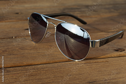 Sunglasses is on the wood table