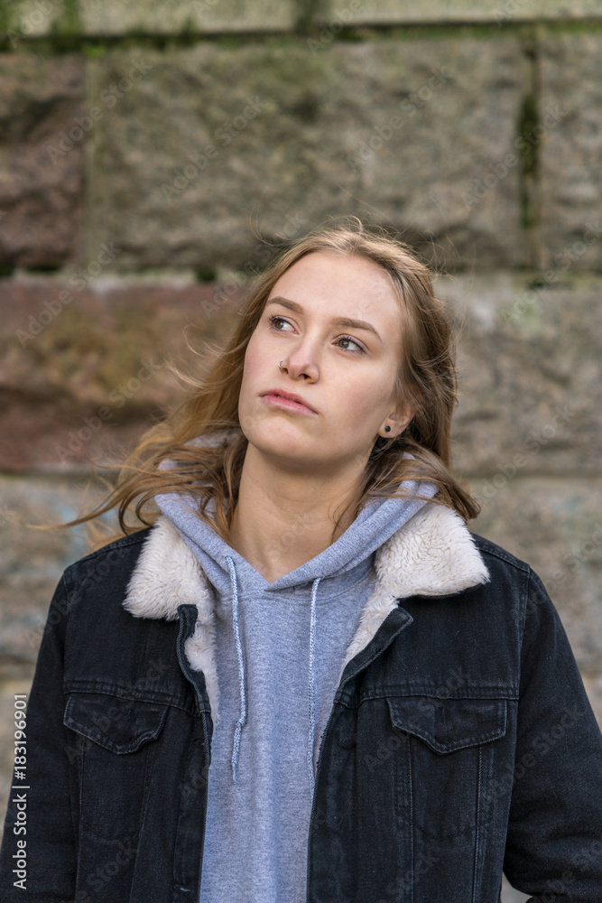 Das Portrait einer jungen Frau vor einer Mauer