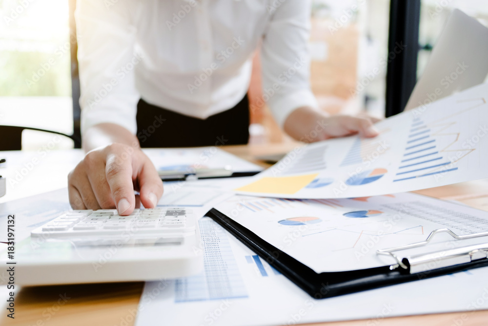 Fototapeta premium Business woman analysis investment perform data document and calculating a valuation number