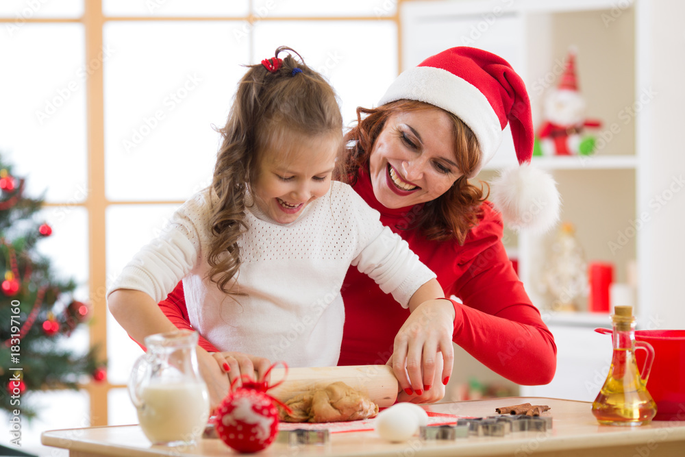 Mother and child daughter making christmas cookies and having fun. Focus on mother Mother and child daughter making christmas cookies and having fun. Focus on mother