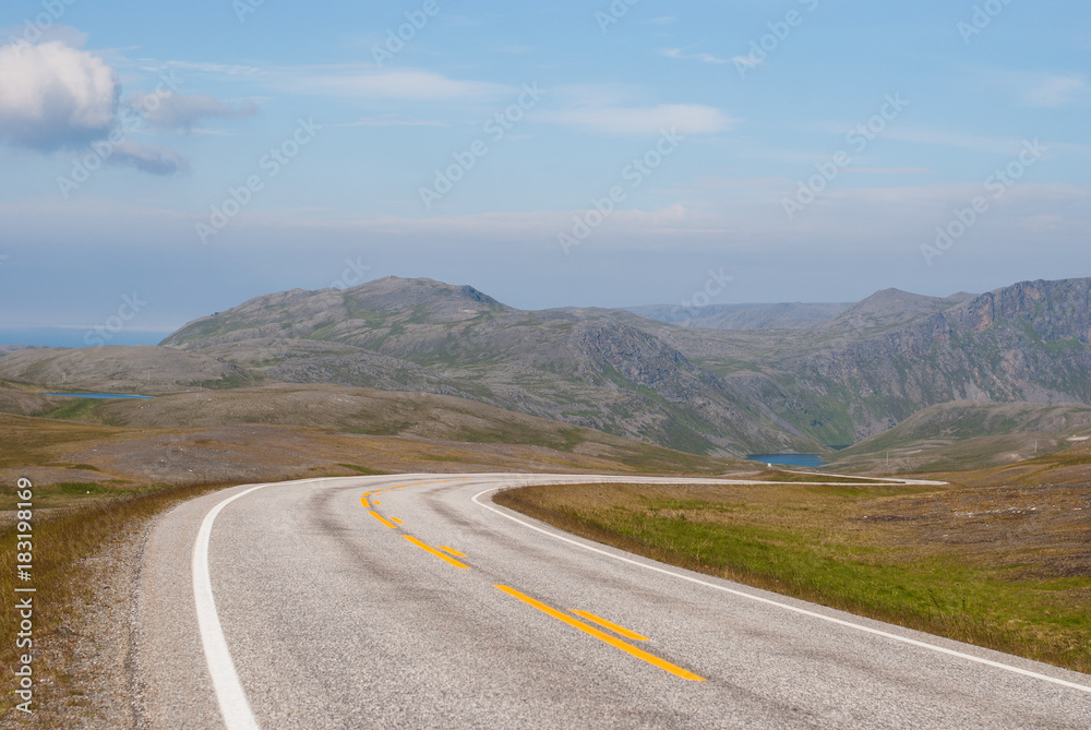 The road is far away against the background of stony hills