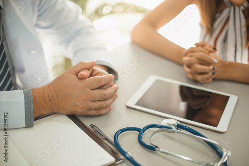 Doctor using her digital tablet in the office. Healthcare professional medical doctor using tablet and smartphone for consult patient via online.