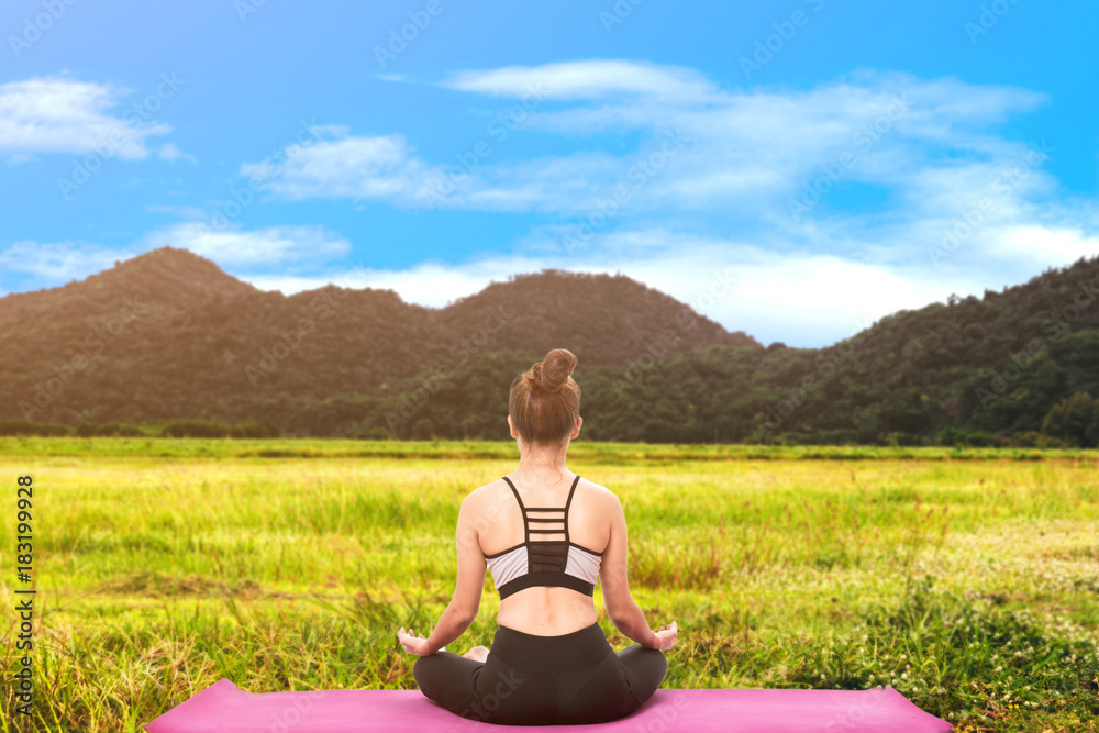 Woman practicing yoga on mountain with blue sky background Woman practicing yoga on mountain with blue sky background