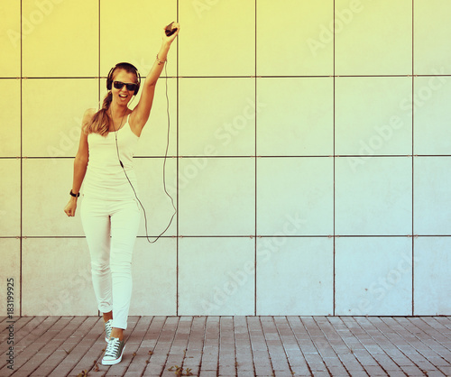 Freedom concept. Young attractive girl listening music with headphone.