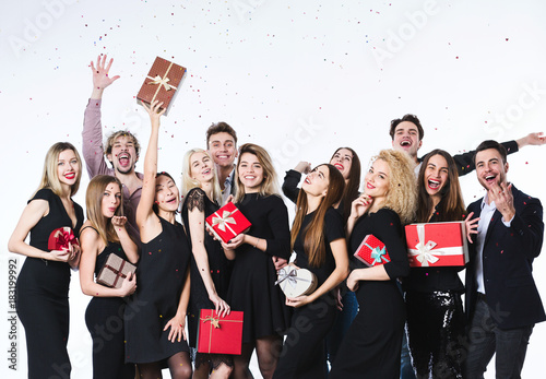 Group of young beautiful people in stylish clothes with gift boxes in hands having fun.