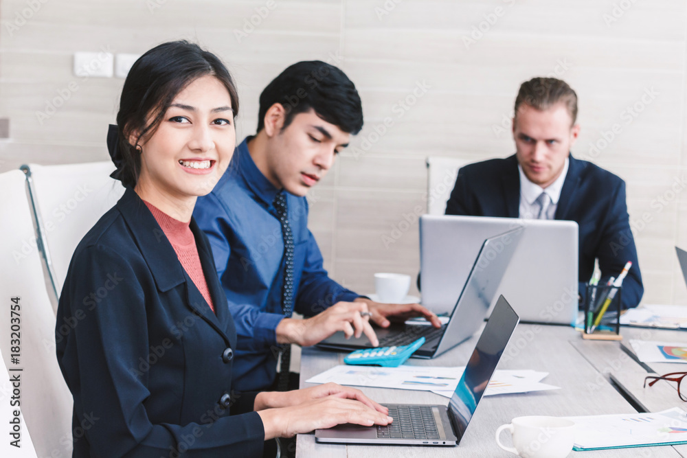 Businesspeople using laptops and discussing together in meeting room.Teamwork concept Businesspeople using laptops and discussing together in meeting room.Teamwork concept