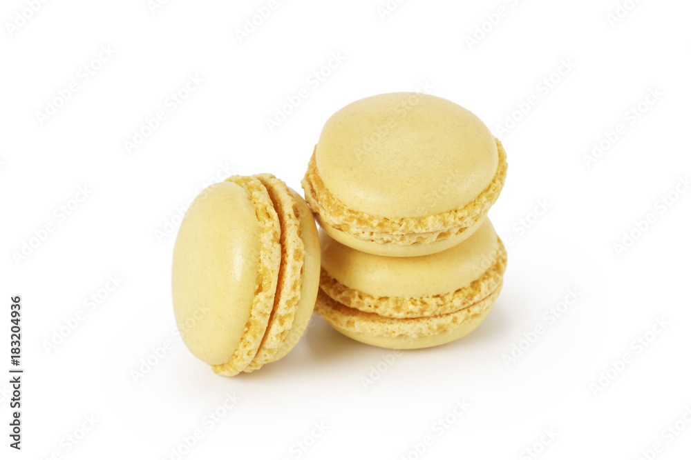 three yellow lemon macarons isolated on white