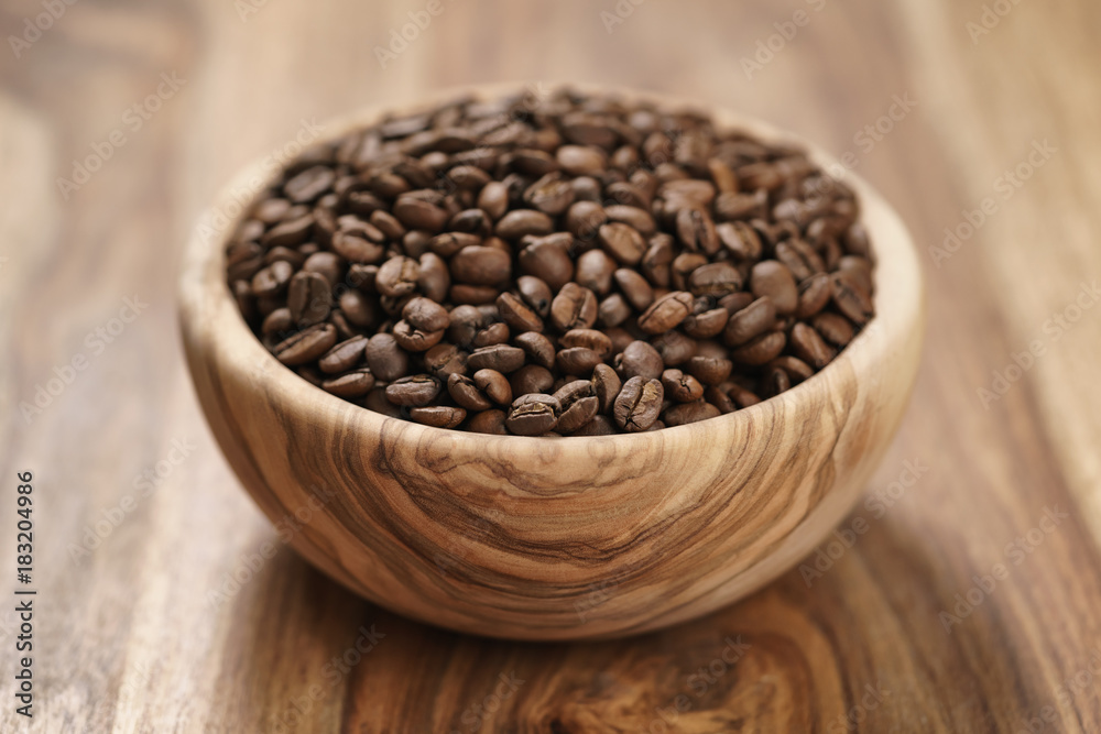 fresh roasted coffee beans in wood bowl on table fresh roasted coffee beans in wood bowl on table